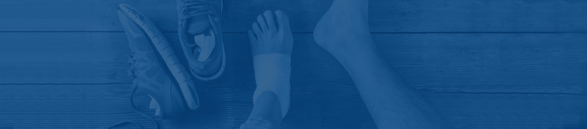 Taped ankle and running shoes, representing an ankle sprain